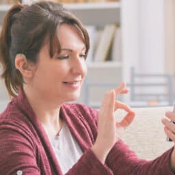 Woman with hearing aid using her smartphone.