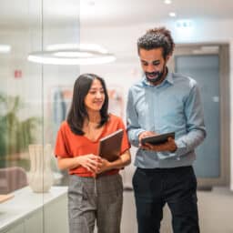 Two coworkers looking at a tablet together