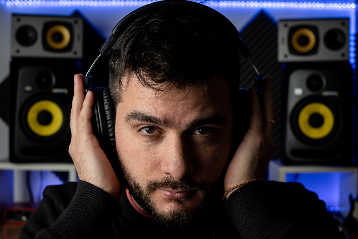 Man holds headphones over ears