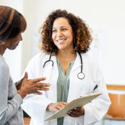 Happy doctor talking to her patient.